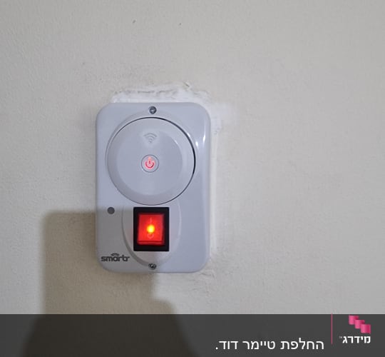 מתג חכם על קיר עם נורית חיווי אדומה